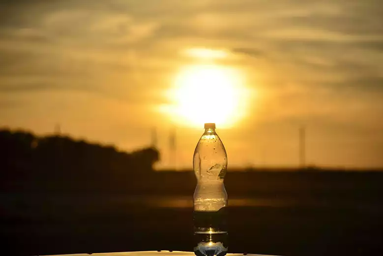 Botella de agua bajo el sol para desinfección